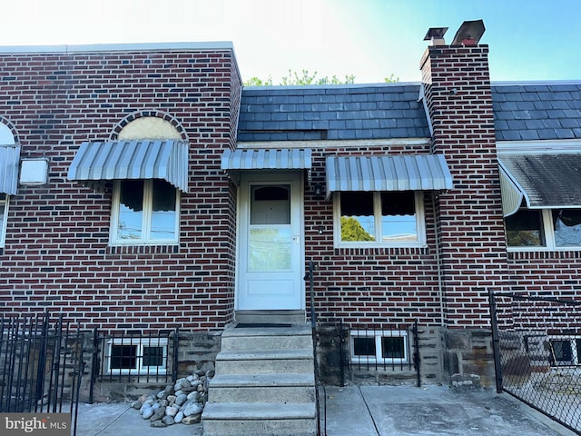 exterior space with brick siding and a chimney