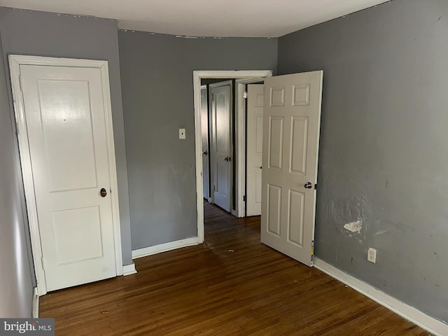 unfurnished bedroom with baseboards and wood finished floors