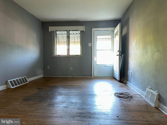 interior space with visible vents, baseboards, and wood finished floors