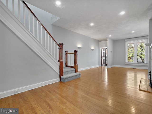 1722 E 30th St E, Baltimore, MD 21218 - unfurnished living room featuring recessed lighting, baseboards, light wood-type flooring, and stairs