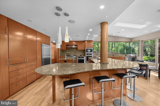 400 Highview Dr, Wayne, PA 19087 - kitchen with built in appliances, a large island with sink, light wood-style floors, a skylight, and recessed lighting