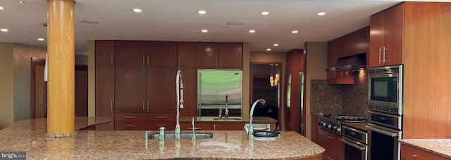 400 Highview Dr, Wayne, PA 19087 - kitchen with wall chimney exhaust hood, built in appliances, modern cabinets, a sink, and tasteful backsplash