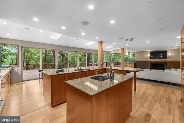 400 Highview Dr, Wayne, PA 19087 - kitchen with a kitchen island with sink, a sink, brown cabinets, light wood-style floors, and recessed lighting