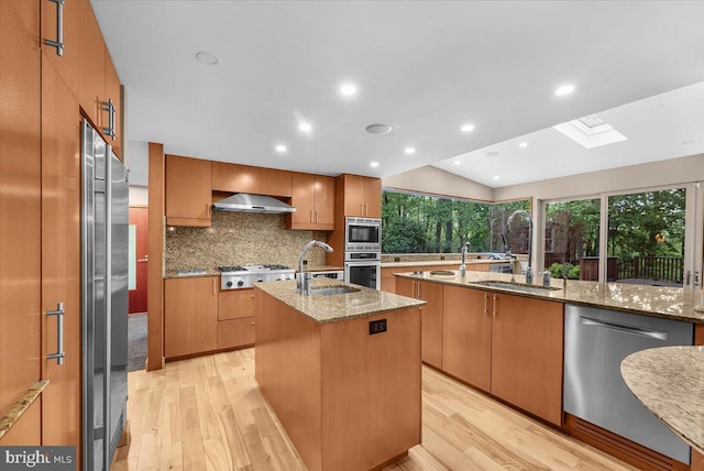 400 Highview Dr, Wayne, PA 19087 - kitchen featuring stainless steel appliances, a kitchen island with sink, a sink, wall chimney exhaust hood, and a skylight