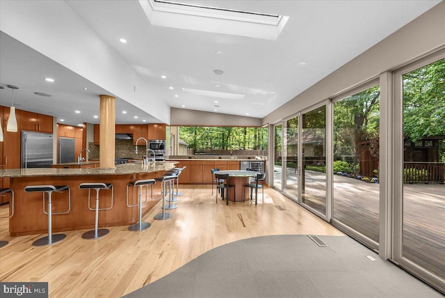 400 Highview Dr, Wayne, PA 19087 - bar featuring built in appliances, light wood-type flooring, backsplash, a skylight, and recessed lighting