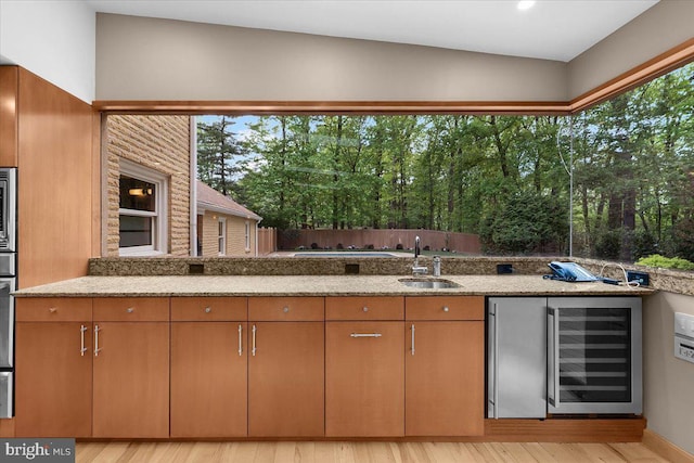 400 Highview Dr, Wayne, PA 19087 - kitchen with wine cooler, a sink, light stone counters, vaulted ceiling, and light wood-style flooring