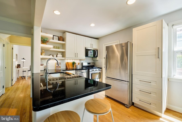 kitchen with backsplash, appliances with stainless steel finishes, a healthy amount of sunlight, and a sink