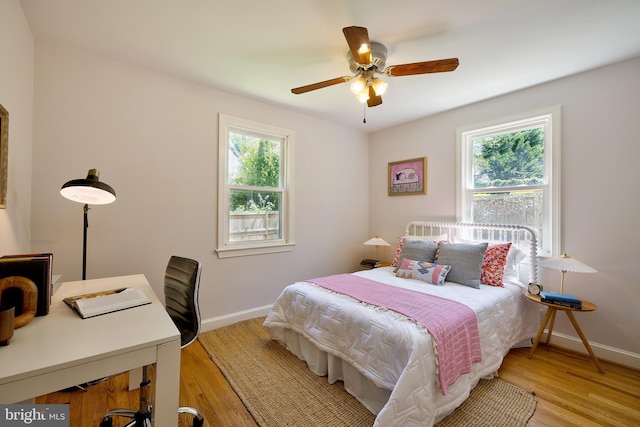 bedroom with baseboards, light wood-style floors, and ceiling fan