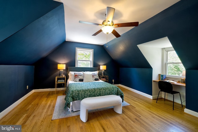 bedroom featuring baseboards, multiple windows, and wood finished floors