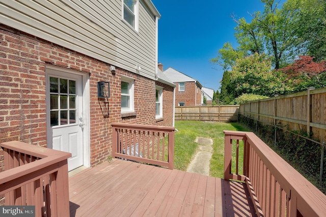 wooden terrace with a fenced backyard and a yard
