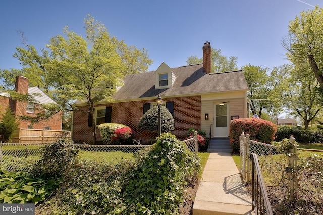 new england style home with fence private yard, brick siding, and a chimney