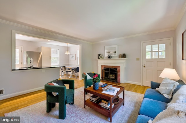 living area featuring crown molding, a wealth of natural light, and light wood-style floors