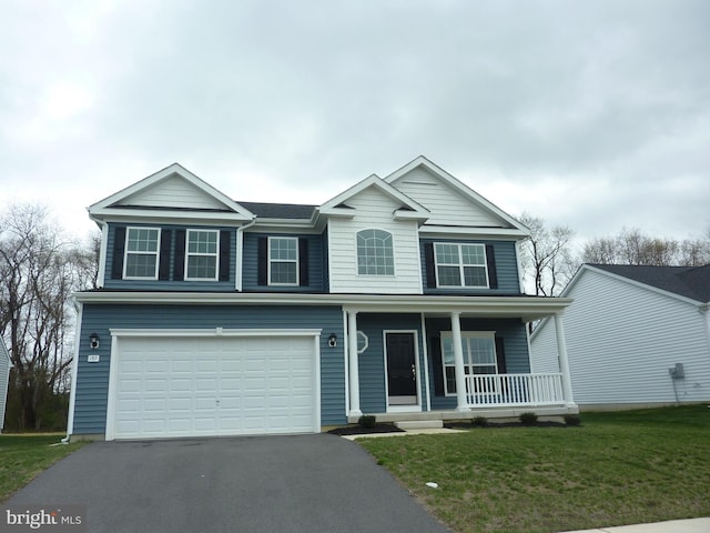 traditional home featuring a front yard, a porch, an attached garage, and aphalt driveway