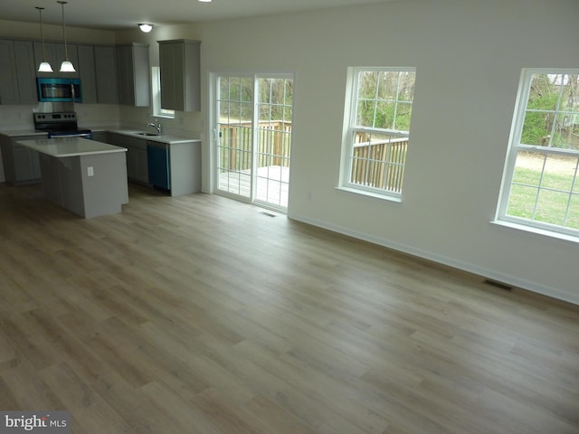 kitchen featuring a wealth of natural light, a kitchen island, visible vents, and appliances with stainless steel finishes