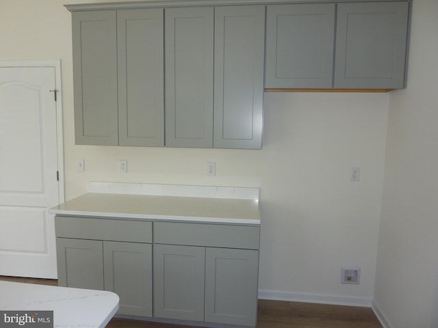 kitchen with gray cabinets, light countertops, and baseboards