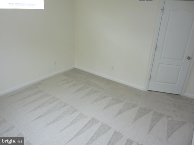 spare room with visible vents, baseboards, and light colored carpet