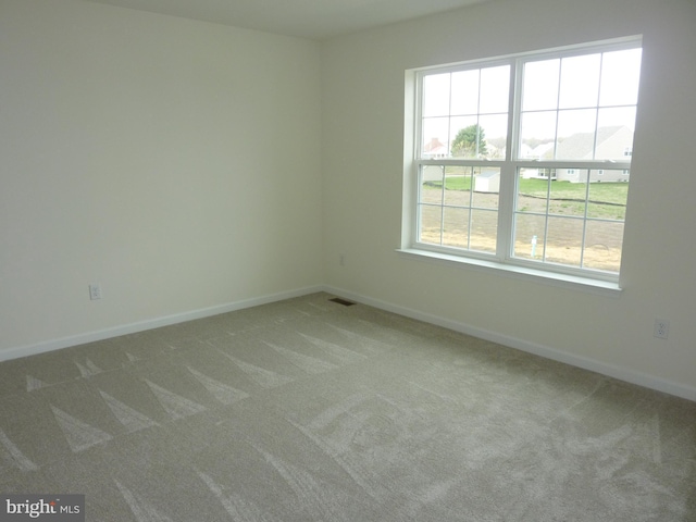 unfurnished room featuring visible vents, baseboards, and carpet flooring