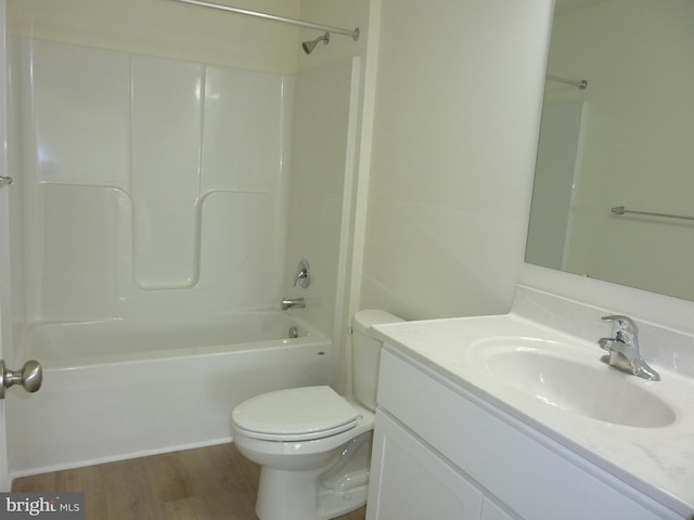 full bathroom featuring washtub / shower combination, toilet, vanity, and wood finished floors