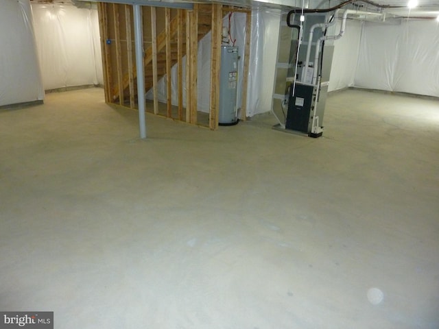 unfinished basement with electric water heater and heating unit