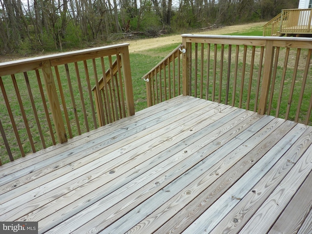 wooden terrace featuring a lawn