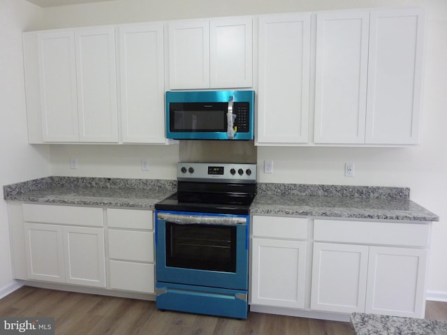 kitchen with stainless steel appliances, light wood finished floors, and white cabinetry
