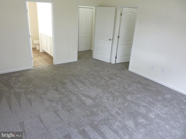 unfurnished bedroom featuring carpet flooring, baseboards, and connected bathroom