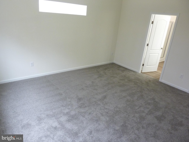 empty room featuring carpet floors and baseboards