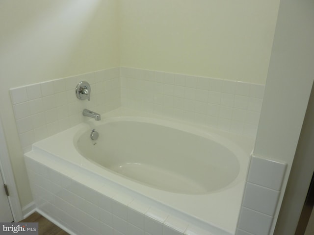 bathroom with a bath and wood finished floors