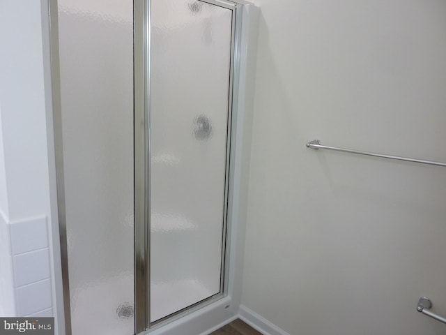 bathroom featuring a stall shower and baseboards
