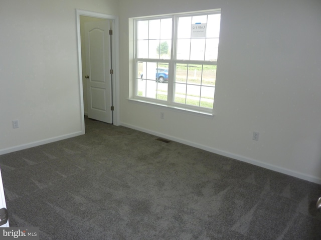 empty room with visible vents, baseboards, and carpet
