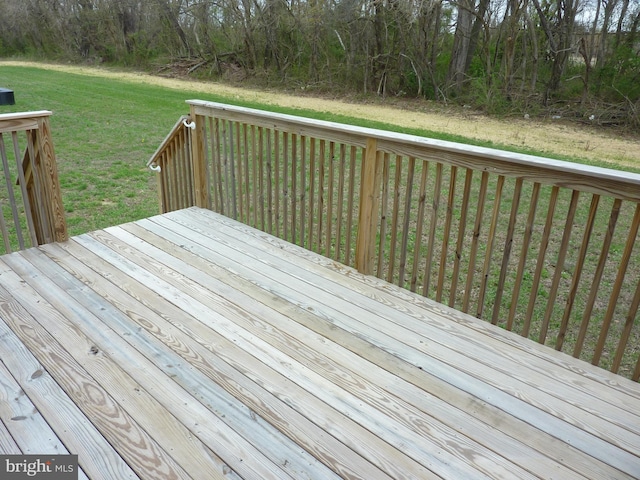 wooden deck with a yard and a forest view