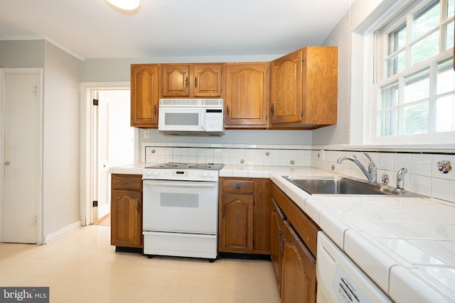 7411 Elizabeth Rd, Elkins Park, PA 19027 - kitchen with white appliances, tile countertops, a sink, brown cabinets, and crown molding