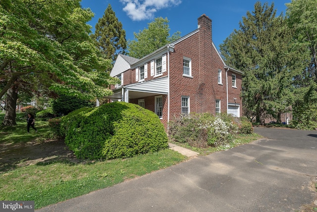 7411 Elizabeth Rd, Elkins Park, PA 19027 - view of home's exterior with brick siding, a chimney, and driveway