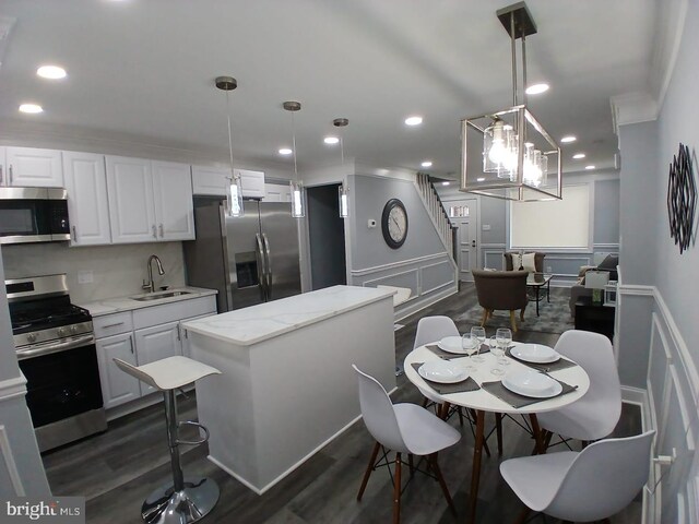 300 Denison St, Baltimore, MD 21229 - kitchen with a sink, dark wood-style flooring, appliances with stainless steel finishes, recessed lighting, and white cabinetry