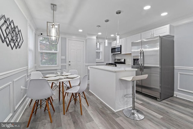 300 Denison St, Baltimore, MD 21229 - kitchen with stainless steel appliances, white cabinets, crown molding, and a kitchen island