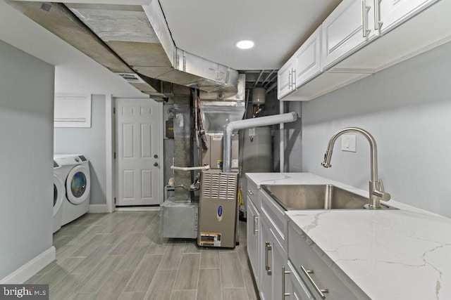 300 Denison St, Baltimore, MD 21229 - laundry room featuring cabinet space, baseboards, a sink, and wood tiled floor