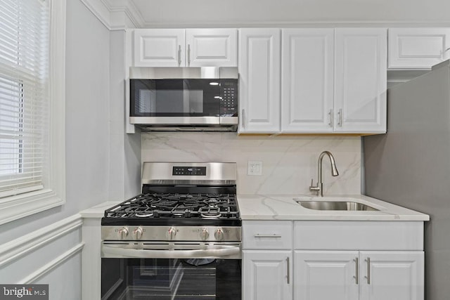 300 Denison St, Baltimore, MD 21229 - kitchen featuring light stone countertops, tasteful backsplash, white cabinets, a sink, and stainless steel appliances