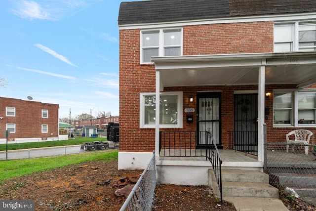 300 Denison St, Baltimore, MD 21229 - property entrance featuring a porch, brick siding, and a shingled roof