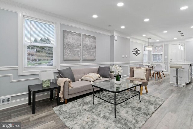 300 Denison St, Baltimore, MD 21229 - living room with a decorative wall, visible vents, ornamental molding, and wood finished floors