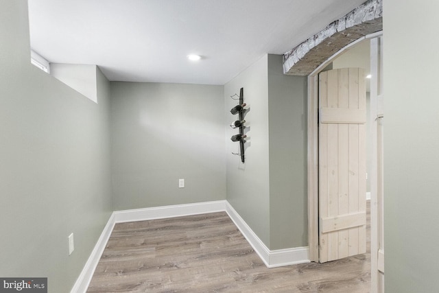 empty room featuring wood finished floors, baseboards, and recessed lighting