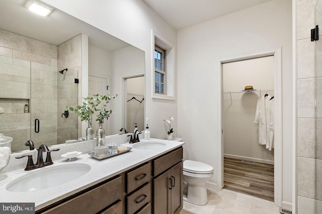 610 Greenbriar Path, Cochranville, PA 19330 - bathroom featuring a stall shower, double vanity, a walk in closet, and tile patterned floors