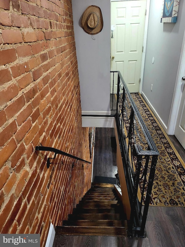 3149 Jasper St, Philadelphia, PA 19134 - stairway with baseboards, brick wall, and wood finished floors