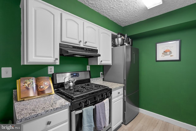 9830 Hollow Glen Pl Unit 2562, Silver Spring, MD 20910 - kitchen featuring stainless steel appliances, under cabinet range hood, white cabinets, baseboards, and light wood finished floors