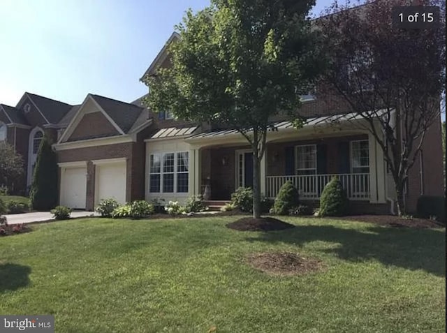 view of front of property with a front yard, a porch, a garage, and concrete driveway