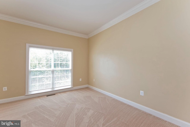 empty room with light colored carpet, visible vents, baseboards, and crown molding