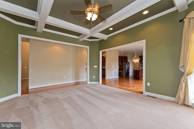 spare room featuring beam ceiling, carpet flooring, coffered ceiling, and visible vents