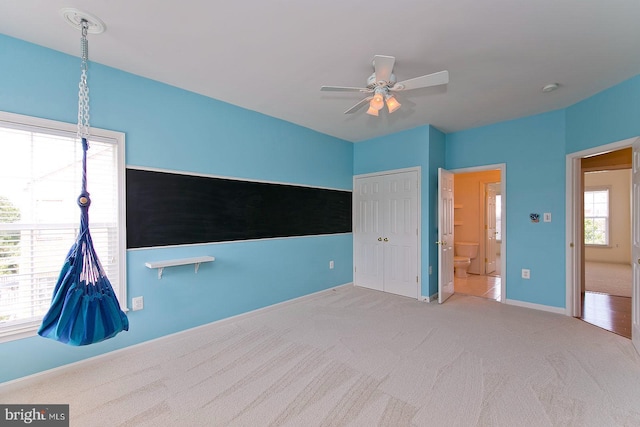 unfurnished bedroom featuring ceiling fan, a closet, carpet flooring, and baseboards