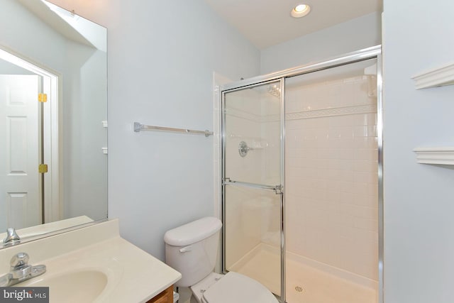 bathroom featuring toilet, a stall shower, vanity, and recessed lighting