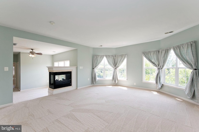 unfurnished living room featuring visible vents, baseboards, carpet flooring, and a healthy amount of sunlight