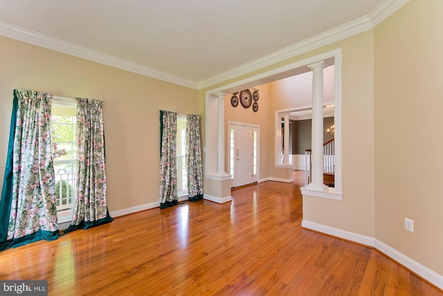 spare room with light wood finished floors, baseboards, ornamental molding, and stairway